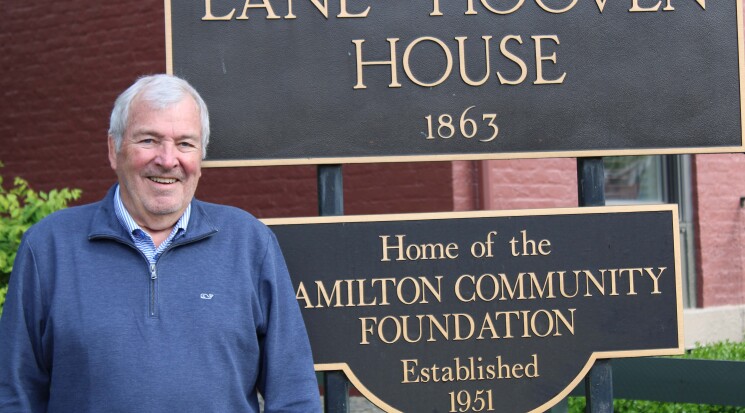 Man in front of Lane Hooven House sign